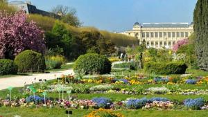 a garden with flowers in front of a building at So Paris Group - Fully Serviced Studio Apartment - Jardin des Plantes - Heart of Paris in Paris