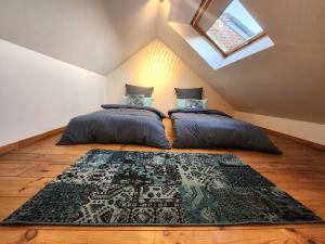 a attic bedroom with two beds and a rug at Appart4you in Namur
