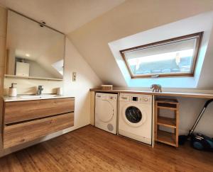 uma casa de banho com uma máquina de lavar roupa e um lavatório em Appart4you em Namur