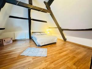 a bedroom with a bed and a wooden floor at La belle époque in Laon