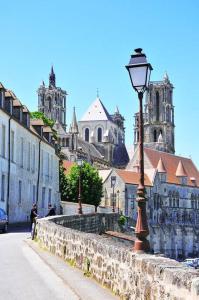 ein Straßenlicht neben einer Steinmauer mit einer Kathedrale in der Unterkunft La belle époque in Laon