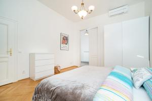 Habitación blanca con cama y lámpara de araña. en Quiet apartment in the Old Town, en Praga