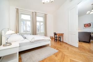 Habitación blanca con cama y escritorio en Quiet apartment in the Old Town, en Praga