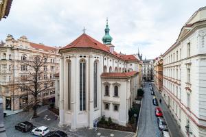 un gran edificio blanco con una cúpula verde en una calle en Quiet apartment in the Old Town, en Praga