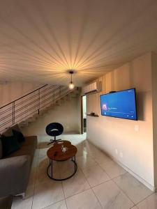 een woonkamer met een bank en een tv aan de muur bij Alpha D7 in Puerto Vallarta