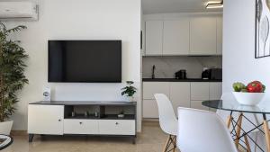 a living room with a tv on a white wall at LAS ARENAS superior seafront in Benidorm