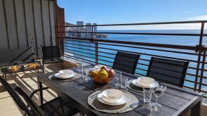 a table with a bowl of fruit on a balcony at LAS ARENAS superior seafront in Benidorm