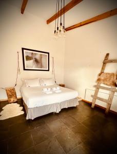 a bedroom with a white bed and a ladder at El Establo in Puerto Natales