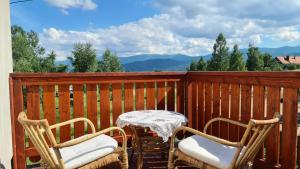 a table and chairs on a balcony with mountains in the background at Nasze Górskie in Wojcieszyce