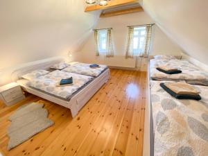 2 Betten in einem Zimmer mit Holzböden und Fenstern in der Unterkunft Chalupa Ludvíkov in Nové Město pod Smrkem
