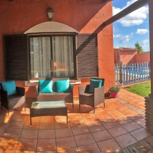 d'un patio avec des chaises et une table. dans l'établissement Agradable casa de playa con piscina. El Palmar, à El Palmar