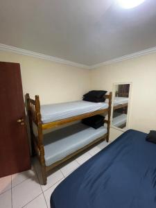 sypialnia z 2 łóżkami piętrowymi w pokoju w obiekcie B12 Casa em Maresias condomínio a 50 metros da praia w mieście Maresias