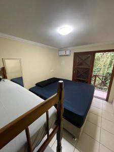 a bedroom with two bunk beds and a window at B12 Casa em Maresias condomínio a 50 metros da praia in Maresias