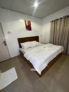 a bedroom with a large bed with white sheets at Mph 4 in Lagos