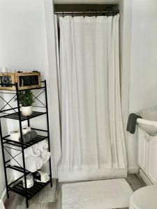 a bathroom with a shower curtain and a shelf with towels at Catskills Hideaway Minutes from Hiking in Mount Tremper