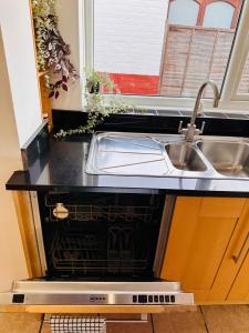 a kitchen counter with a sink and a dishwasher at R5 - Private Studio self contained En-suite Room in Newly renovated house in Birmingham B62 in Quinton