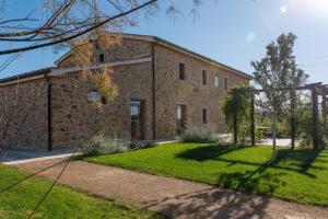 un edificio de ladrillo con un patio de hierba delante de él en Relais Lungagnola, en Casa Lappi