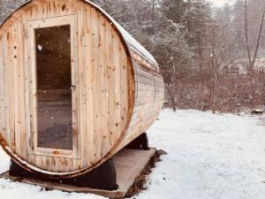 Quaint Cottage w Peloton & Sauna near skiing في Mount Tremper: وجود قارب خشبي جالس في حقل ثلجي مغطى