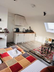 a room with a kitchen with a table and a rug at R5 - Private Studio self contained En-suite Room in Newly renovated house in Birmingham B62 in Quinton