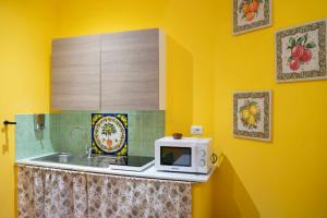 a kitchen with a sink and a microwave on a counter at Sicilia Bedda Taormina in Taormina