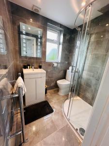 a bathroom with a shower and a sink and a toilet at R5 - Private Studio self contained En-suite Room in Newly renovated house in Birmingham B62 in Quinton
