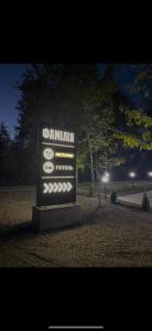 a sign in a park at night at Готельно-ресторанний комплекс Фамілія in Bushtyno