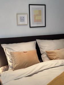 uma cama com lençóis brancos e almofadas num quarto em Gemütliche Ferienwohnung am Kurpark em Bad Camberg