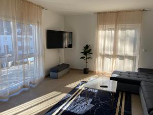 ein Wohnzimmer mit einem Sofa und einem Flachbild-TV in der Unterkunft Valley of Business Frankfurt-West - Apartment Nº2 - Two-Bedroom in Hofheim am Taunus
