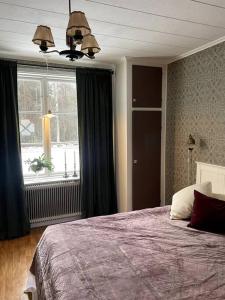 Un dormitorio con una cama grande y una ventana en Gamla gården i Ersmark Umeå, en Umeå