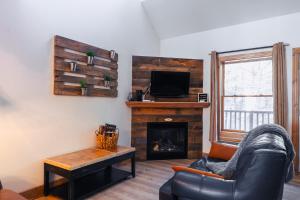 sala de estar con sofá y chimenea en La petite saisonnière en Mont-Tremblant