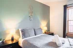 1 dormitorio con 1 cama, 2 lámparas y ventana en La petite saisonnière en Mont-Tremblant