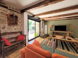 a living room with a couch and a tv at Ferme pleine nature en Corrèze in Saint-Yrieix-le-Déjalat