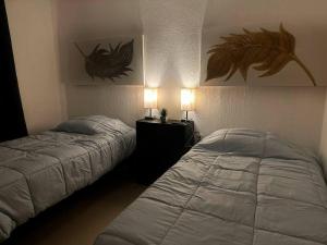 una camera con due letti e due lampade a muro di Departamento En Bahía de Banderas a Conchas