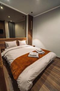 a bedroom with a large bed with two towels on it at INDIVIDUALliving3 in Thessaloniki