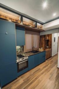 a large kitchen with blue cabinets and a stove at INDIVIDUALliving3 in Thessaloniki