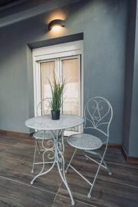 un tavolo e due sedie con una pianta in vaso di INDIVIDUALliving3 a Salonicco