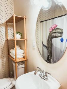 uma casa de banho com um lavatório e um dinossauro no espelho em Artist's Bungalow - 1/2 mi from Covington Square em Covington