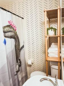 uma casa de banho com uma cabeça de dinossauro na cortina do chuveiro em Artist's Bungalow - 1/2 mi from Covington Square em Covington