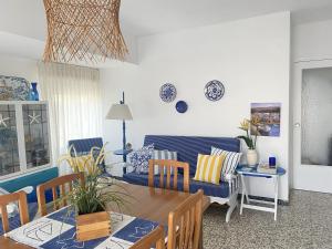 een woonkamer met een tafel en een blauwe bank bij Apartamento familiar a 200m de la playa in Alcossebre