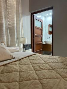 - une chambre avec un grand lit et une salle de bains dans l'établissement La Posta del Jesuita, à Villa Los Aromos
