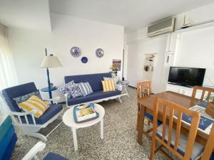 een woonkamer met een blauwe bank en stoelen bij Apartamento familiar a 200m de la playa in Alcossebre