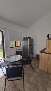 um quarto com uma mesa e cadeiras e um frigorífico em Las cabañas de macarena em Punta del Este