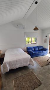 - une chambre avec un lit et un canapé bleu dans l'établissement Las cabañas de macarena, à Punta del Este