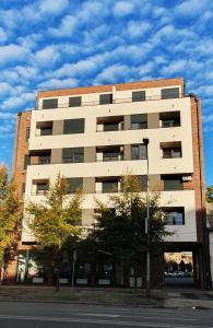 a large white building on the side of a street at APARTMAN 52 - Privatni parking za goste in Novi Sad