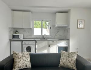 a living room with a couch and a kitchen at Apartamentos LlAMAR in Puerto del Carmen