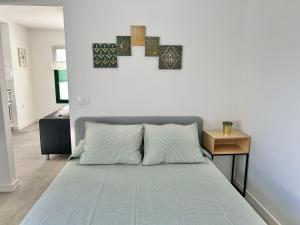 sypialnia z dużym łóżkiem i niebieskim kocem w obiekcie Apartamentos LlAMAR w Puerto del Carmen
