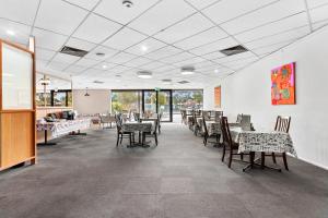 a dining room with tables and chairs and windows at Quality Inn & Suites Traralgon in Traralgon