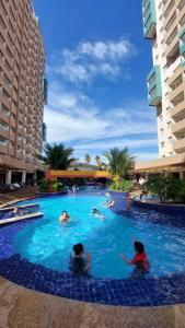 a group of people swimming in a swimming pool at 2 DORMITÓRIOS FRENTE AO THERMAS DOS LARANJAIS in Olímpia