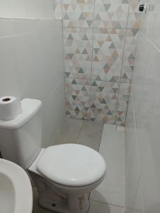 a white bathroom with a toilet and a sink at Apartamento Acochegante in Manaus