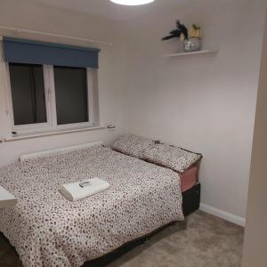 a bedroom with a bed and a window with a white at Double room in a cul de sac area in Wellingborough